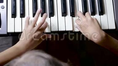 特写镜头中钢琴钥匙的手。 孩子学弹钢琴